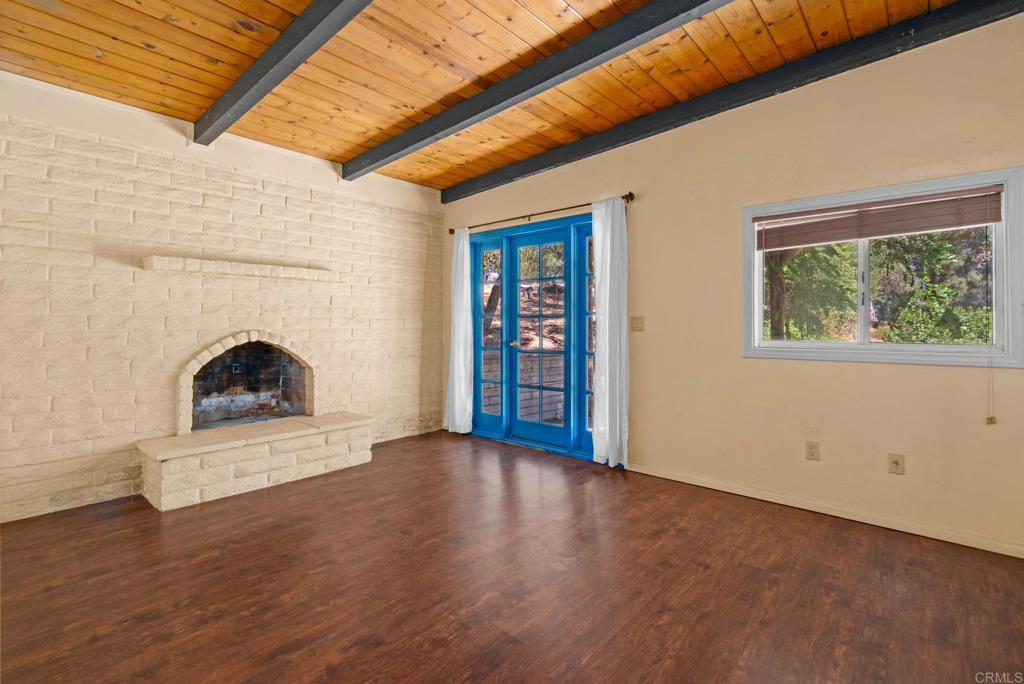 13511 Hilldale Road Valley Center, CA 92082 - Photo 7 of 46 a view of an empty room with wooden floor fireplace and a window