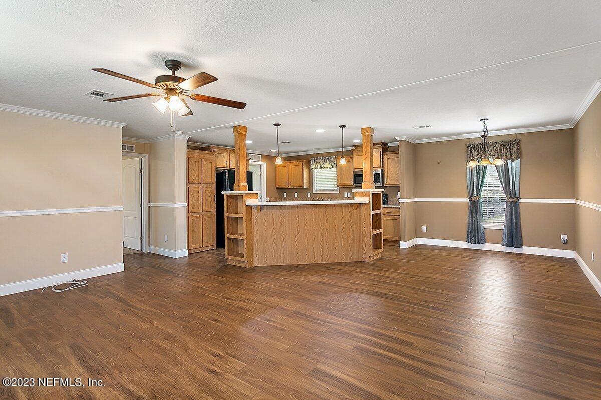 3823 Rancho Road Jacksonville, FL 32221 - Photo 3 of 17 a view of a kitchen with a refrigerator a ceiling fan and wooden floor