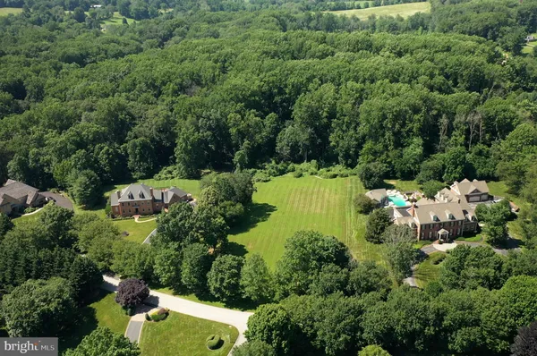 an aerial view of residential house with outdoor space and trees all around