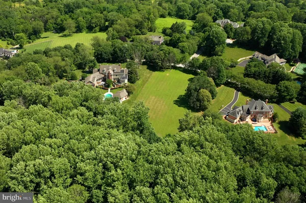 an aerial view of residential house with outdoor space and trees all around
