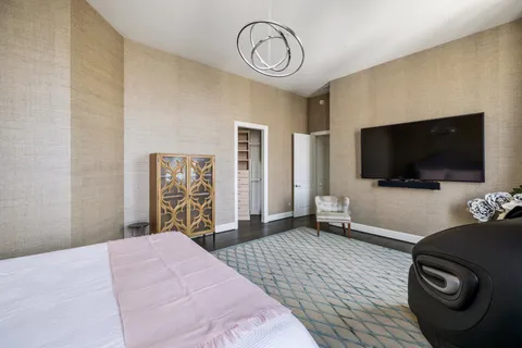 a spacious bedroom with a bed and glass windows