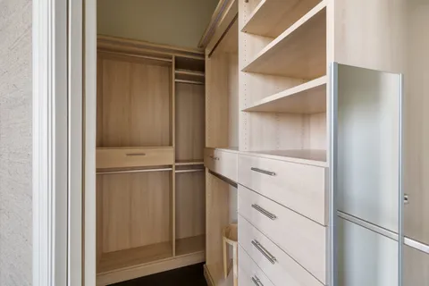 a view of walk in closet with empty racks