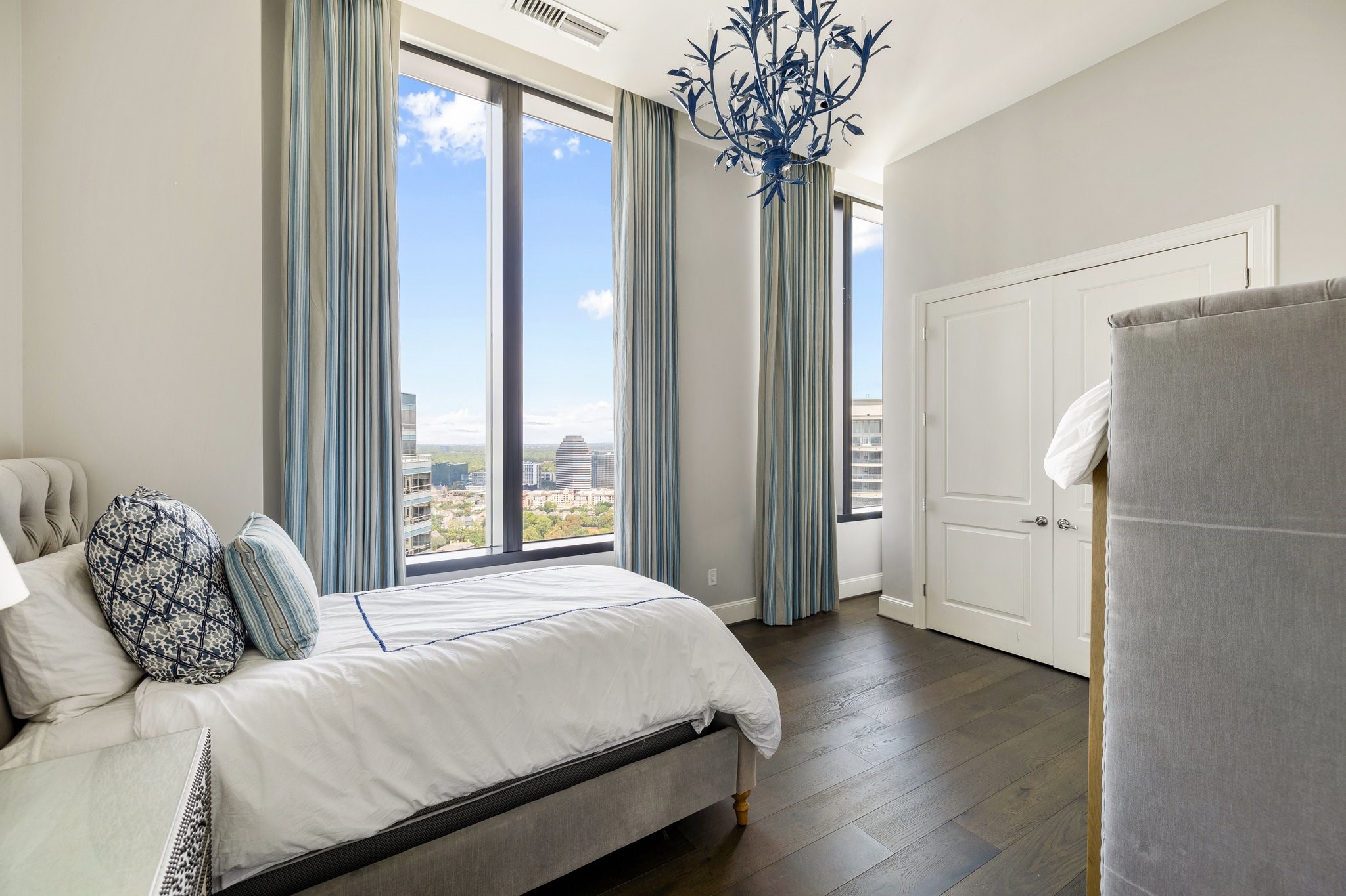 1409 Post Oak Boulevard, Unit 2702 Houston, TX 77056 - Photo 26 of 43 a bedroom with a large bed and a chandelier