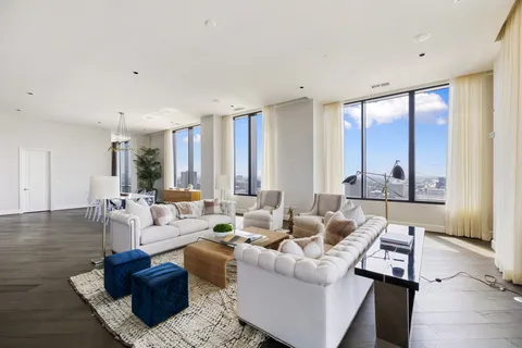 a living room with furniture and large windows