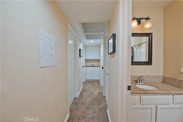a en suite bathroom with a granite countertop sink and a mirror