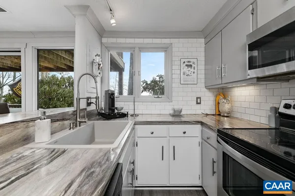 a kitchen with granite countertop a sink stainless steel appliances and cabinets