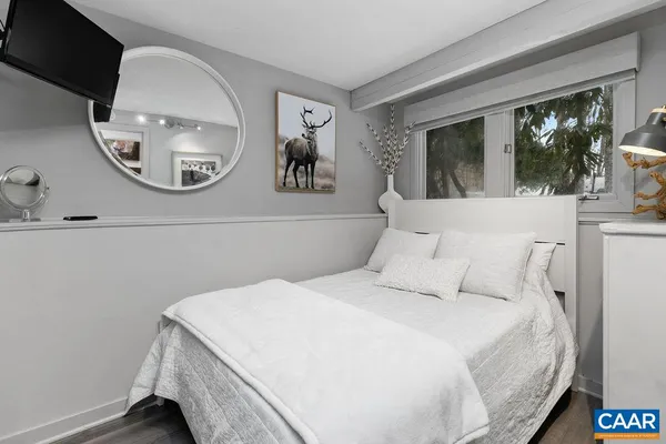 a bedroom with a large bed and a mirror