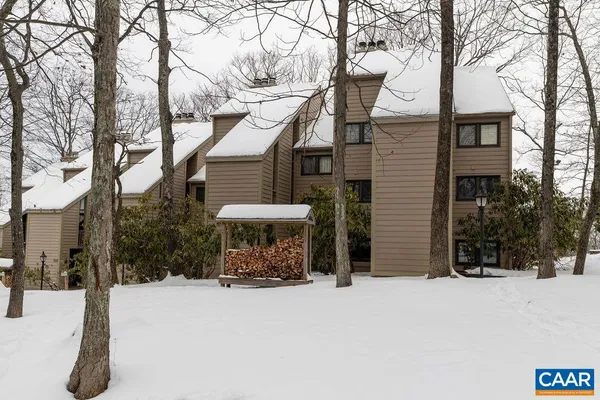 a view of a house with a yard covered in snow