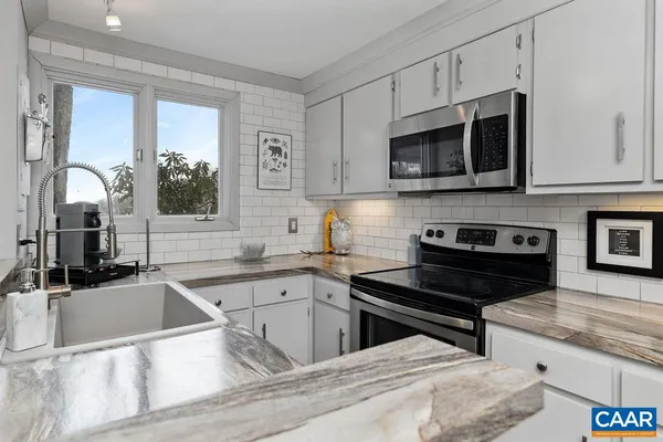 a kitchen with stainless steel appliances a stove sink microwave and cabinets
