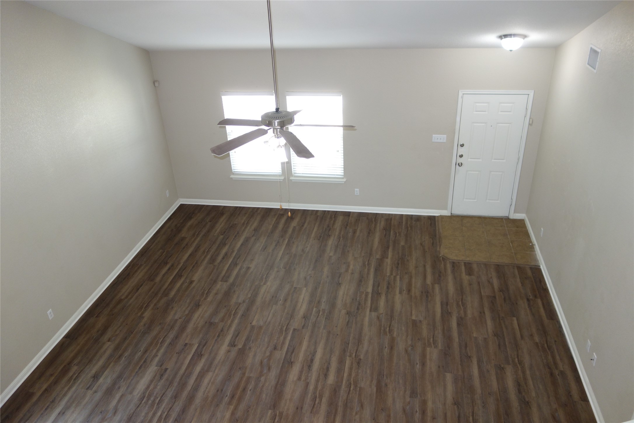 108 Lavaca Loop Hutto, TX 78634 - Photo 7 of 39 an empty room with wooden floor a ceiling fan and windows
