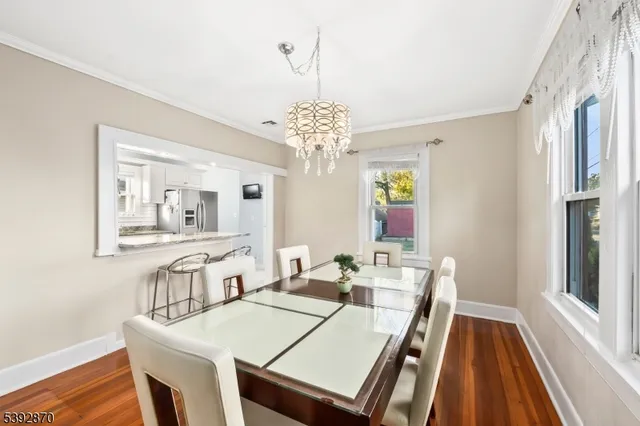 a dining room with wooden floor and chandelier