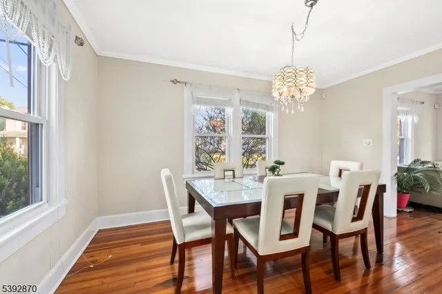 a view of a dining room with furniture a chandelier and wooden floor