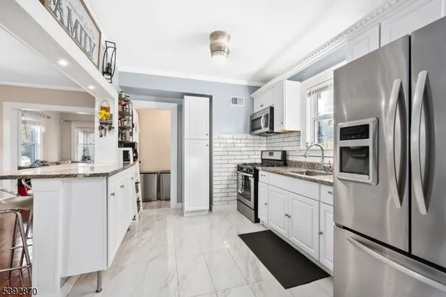 a kitchen with stainless steel appliances a refrigerator sink and microwave