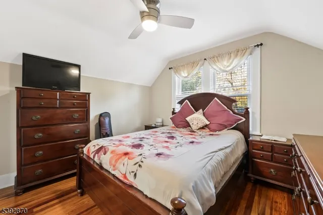 a bedroom with a bed and a flat tv screen on dresser