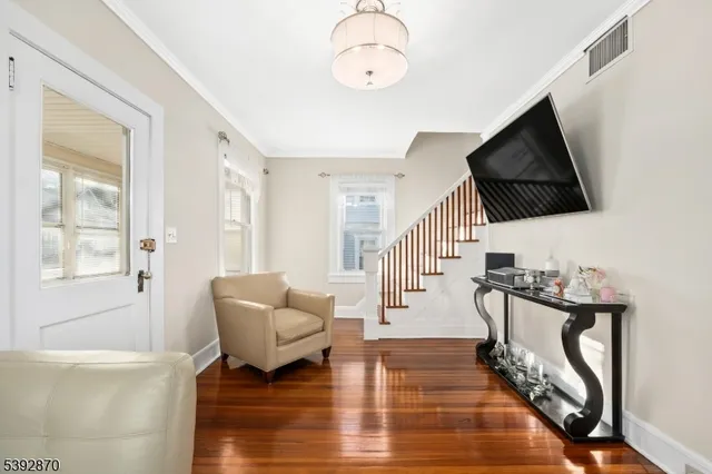 a living room with furniture floor to ceiling window and a flat screen tv