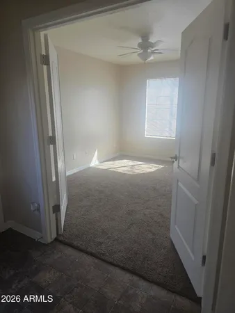 an empty room with windows and fan