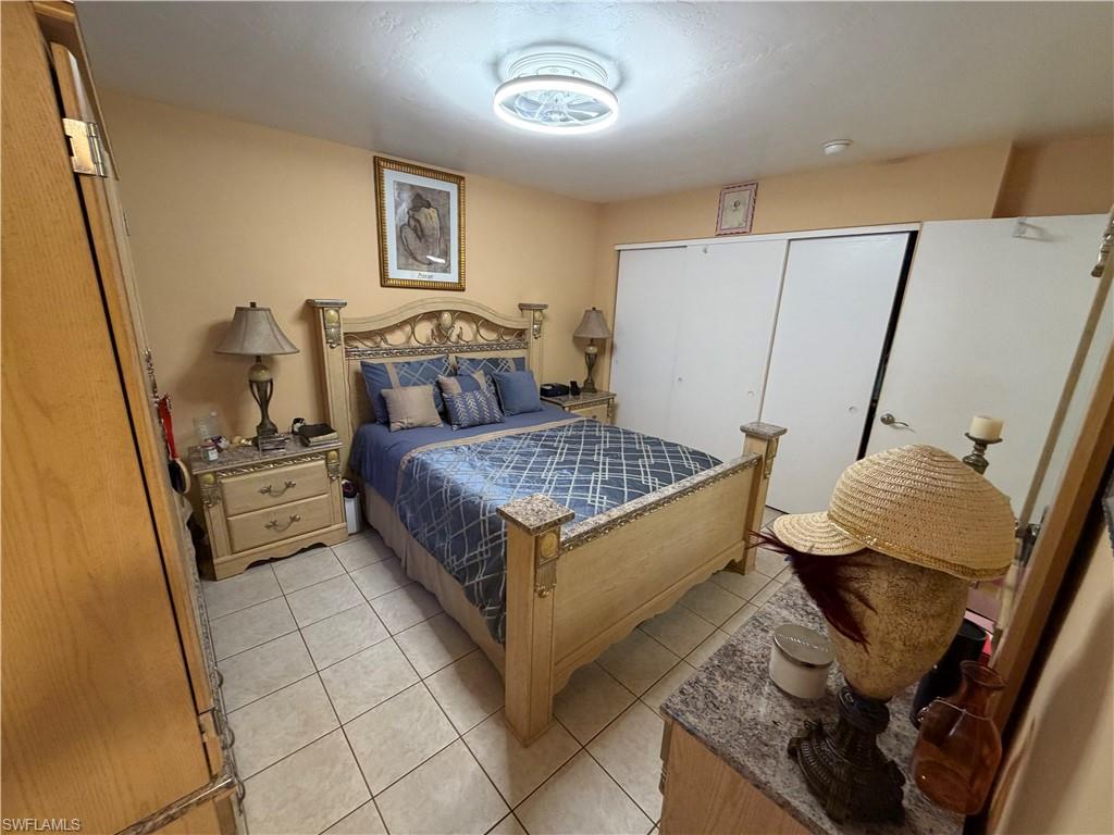 5352 16th Place Southwest, Unit G2 Naples, FL 34116 - Photo 11 of 17 a bedroom with a bed and a flat tv screen on the dresser