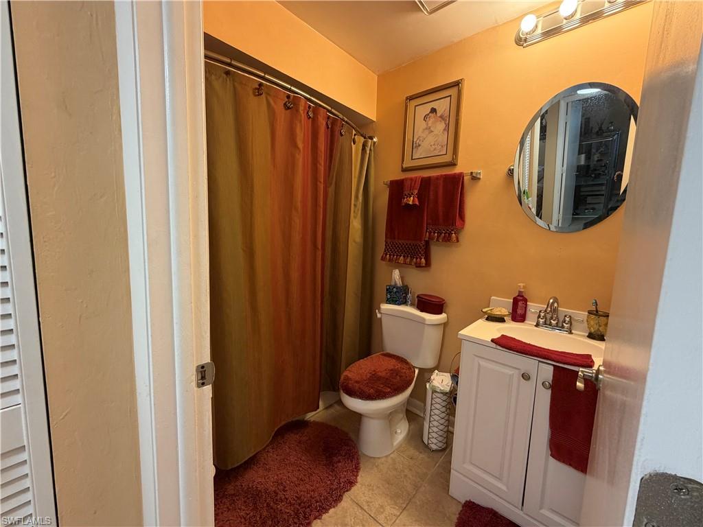 5352 16th Place Southwest, Unit G2 Naples, FL 34116 - Photo 14 of 17 a bathroom with a toilet and a mirror
