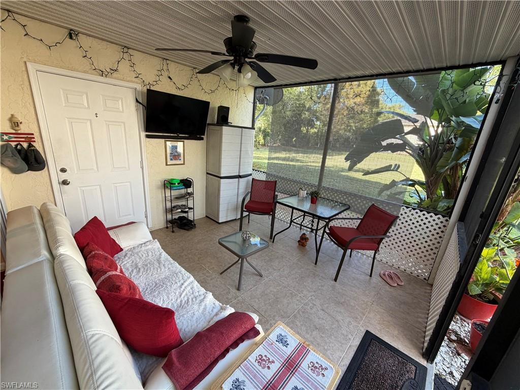 5352 16th Place Southwest, Unit G2 Naples, FL 34116 - Photo 15 of 17 a living room with furniture and a floor to ceiling window