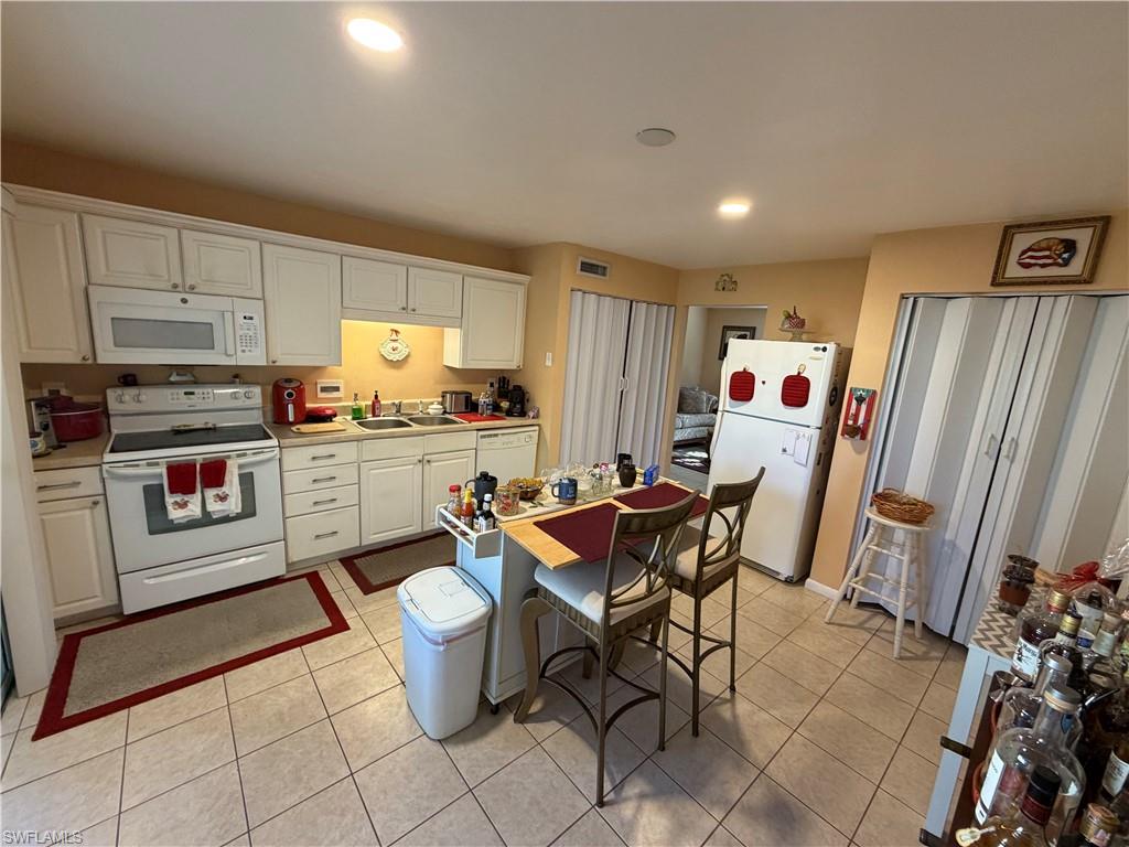 5352 16th Place Southwest, Unit G2 Naples, FL 34116 - Photo 9 of 17 a kitchen with a sink and a refrigerator