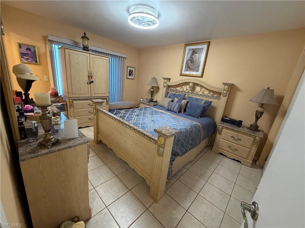 5352 16th Place Southwest, Unit G2 Naples, FL 34116 - Photo 10 of 17 a bedroom with a bed and a mirror