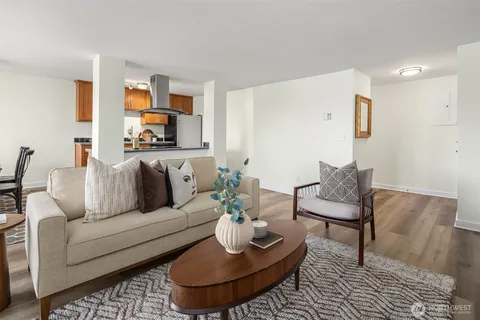 a living room with furniture and a dining table with rug