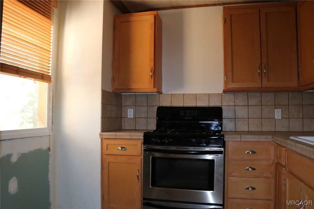 1247 Piney Ridge Place Fawnskin, CA 92333 - Photo 4 of 37 a kitchen with stainless steel appliances wooden cabinets and a stove top oven