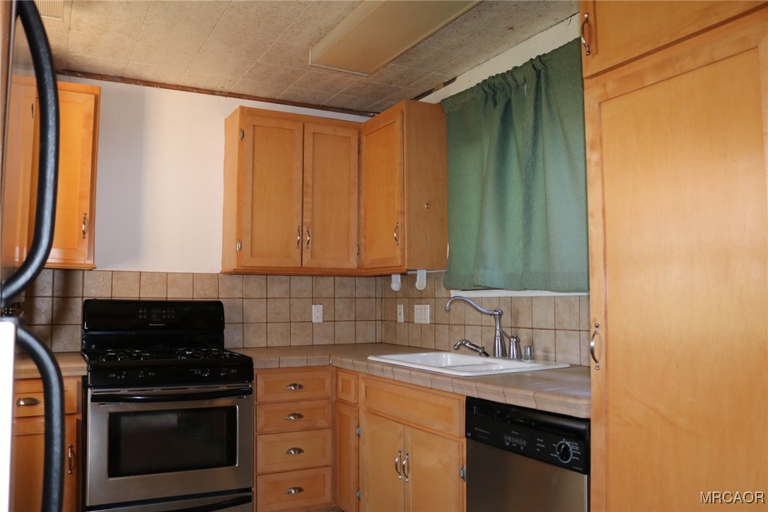 1247 Piney Ridge Place Fawnskin, CA 92333 - Photo 5 of 37 a kitchen with a sink stove and cabinets