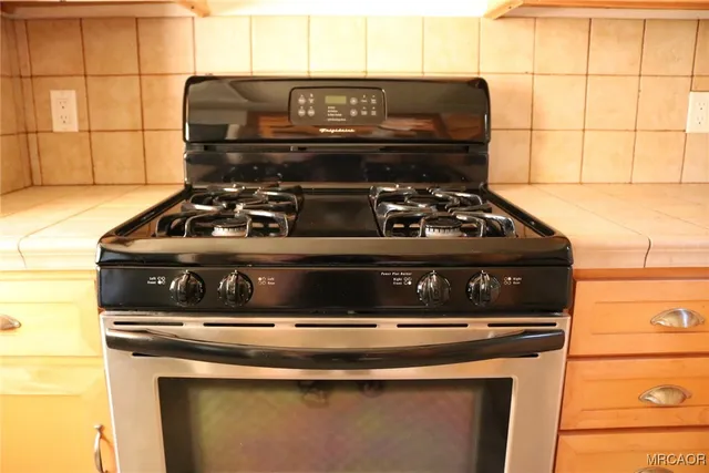 a stove sitting inside of a kitchen with wooden floor
