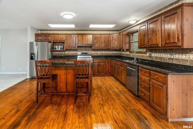 17937 Caplinger Pond Road Marion, IL 62959 - Photo 16 of 43 a kitchen with stainless steel appliances granite countertop wooden floors and wooden cabinets