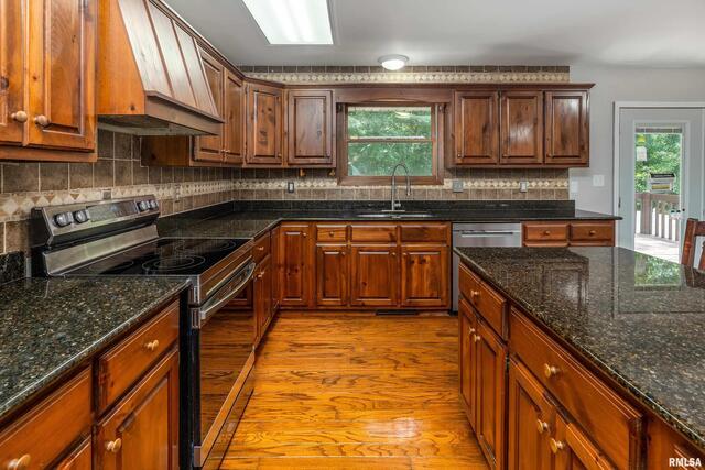 17937 Caplinger Pond Road Marion, IL 62959 - Photo 17 of 43 a kitchen with stainless steel appliances granite countertop a sink a stove top oven a counter space and cabinets