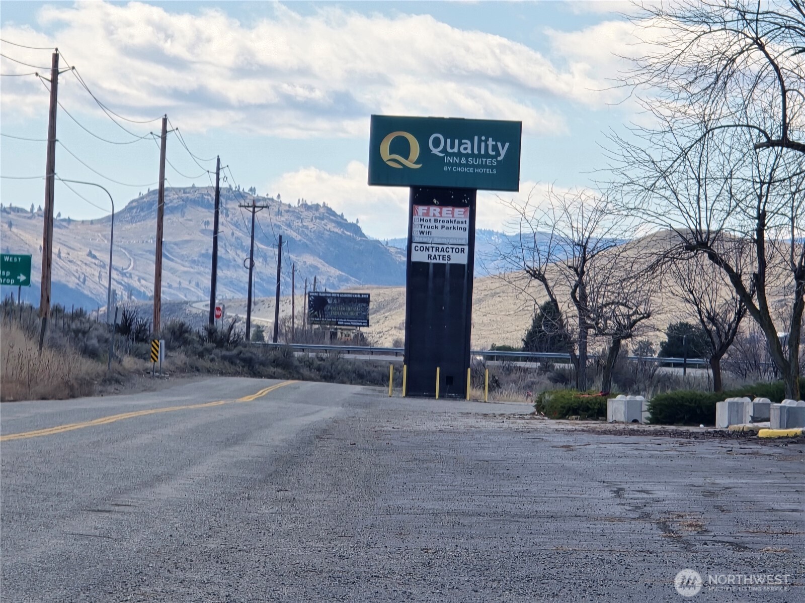 a street sign on a sidewalk next to a road