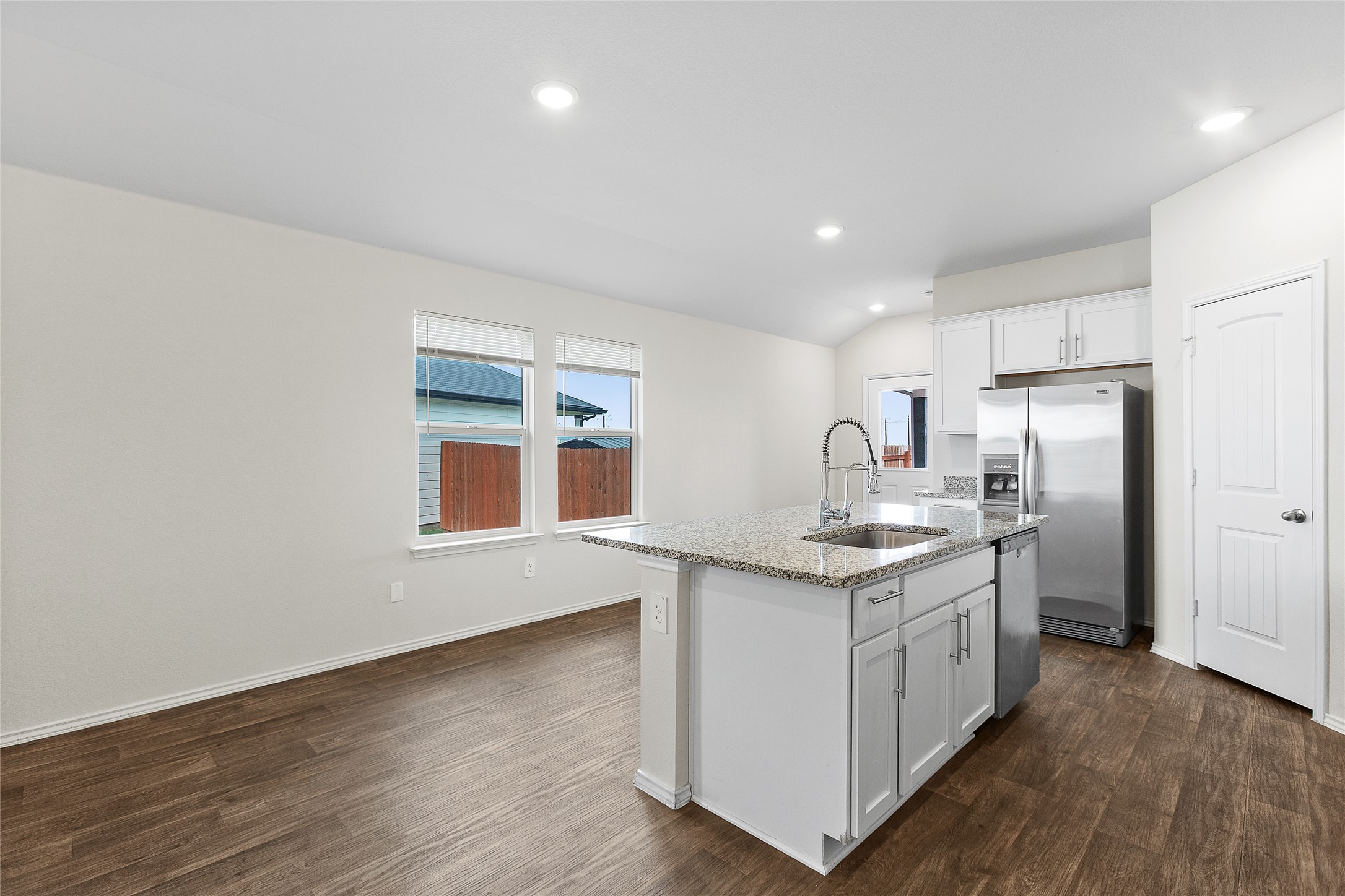 A well-appointed kitchen island with granite countertops anchors this bright, open-concept living space.