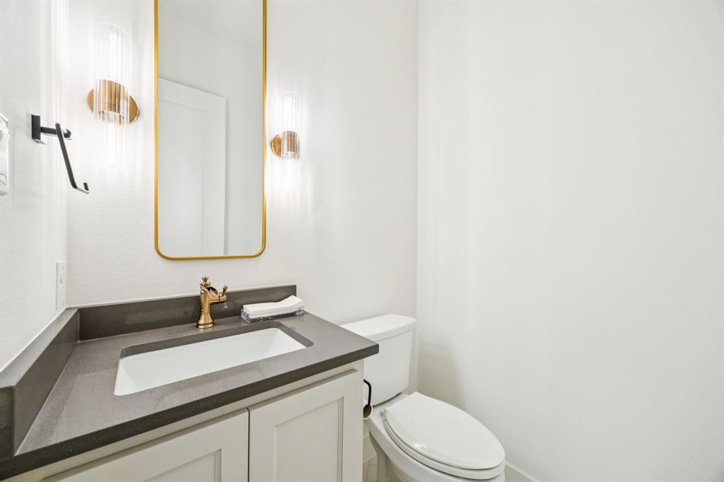 2429 Gallant Fox Road Celina, TX 75009 - Photo 32 of 39 a bathroom with a granite countertop sink and a mirror with toilet