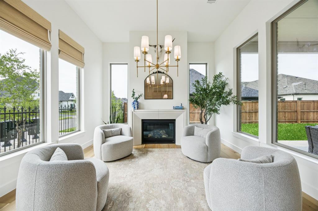 2429 Gallant Fox Road Celina, TX 75009 - Photo 8 of 39 a living room with furniture a fireplace and a large window