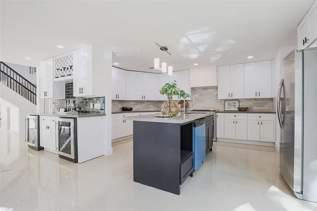 a kitchen with kitchen island granite countertop a sink counter top space cabinets and stainless steel appliances