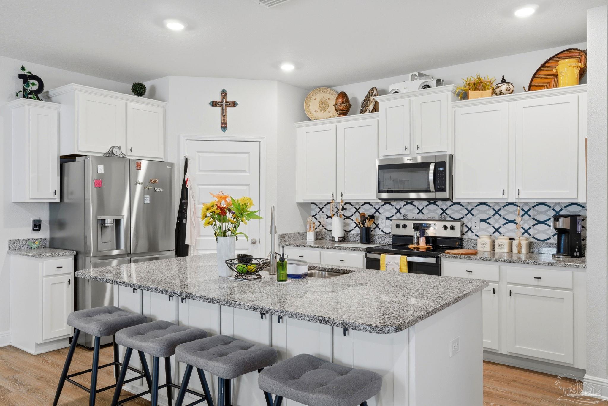 7829 Burnside Loop Pensacola, FL 32526 - Photo 12 of 34 a kitchen with stainless steel appliances kitchen island granite countertop a sink and cabinets