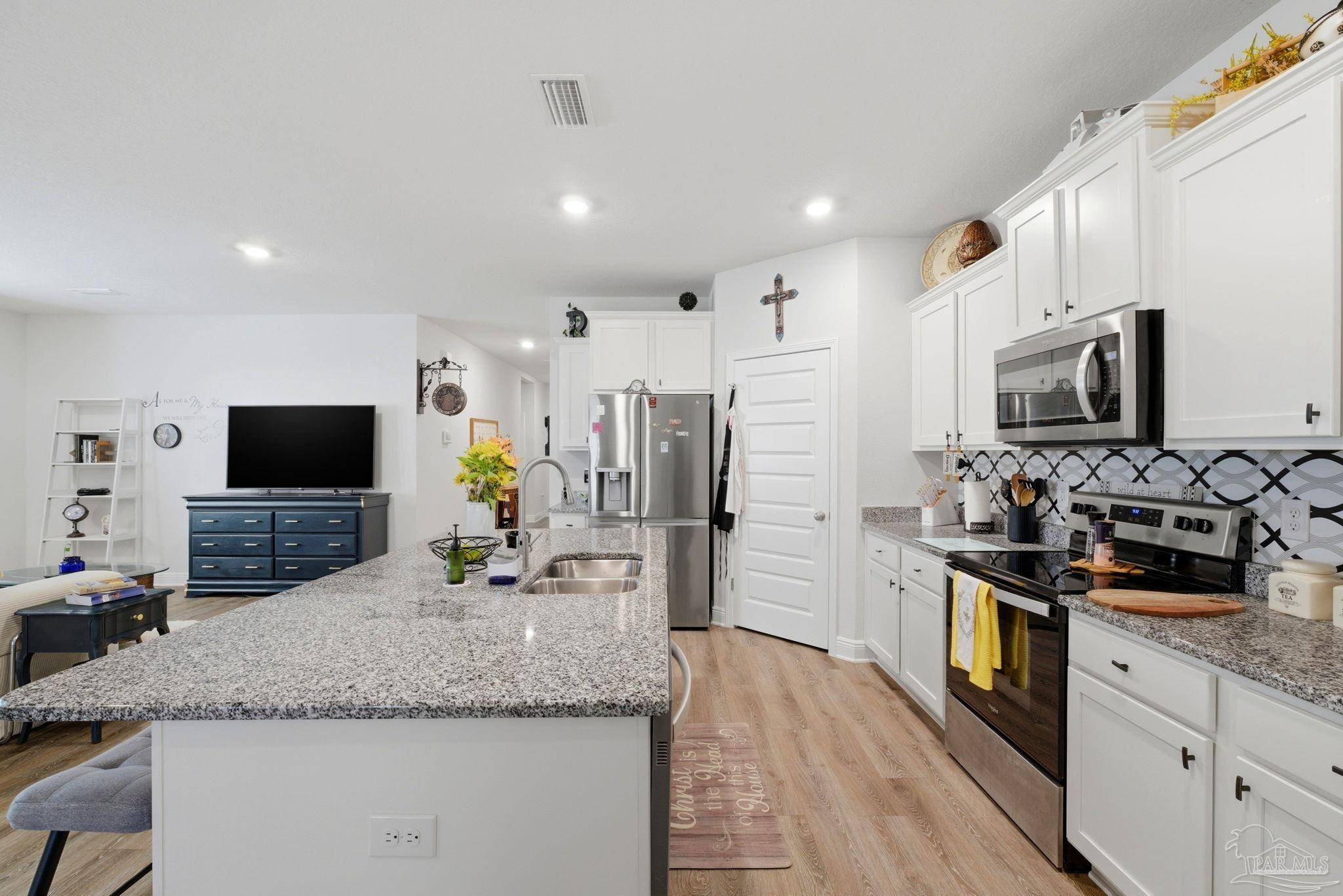 7829 Burnside Loop Pensacola, FL 32526 - Photo 13 of 34 a kitchen with stainless steel appliances granite countertop a sink refrigerator and microwave