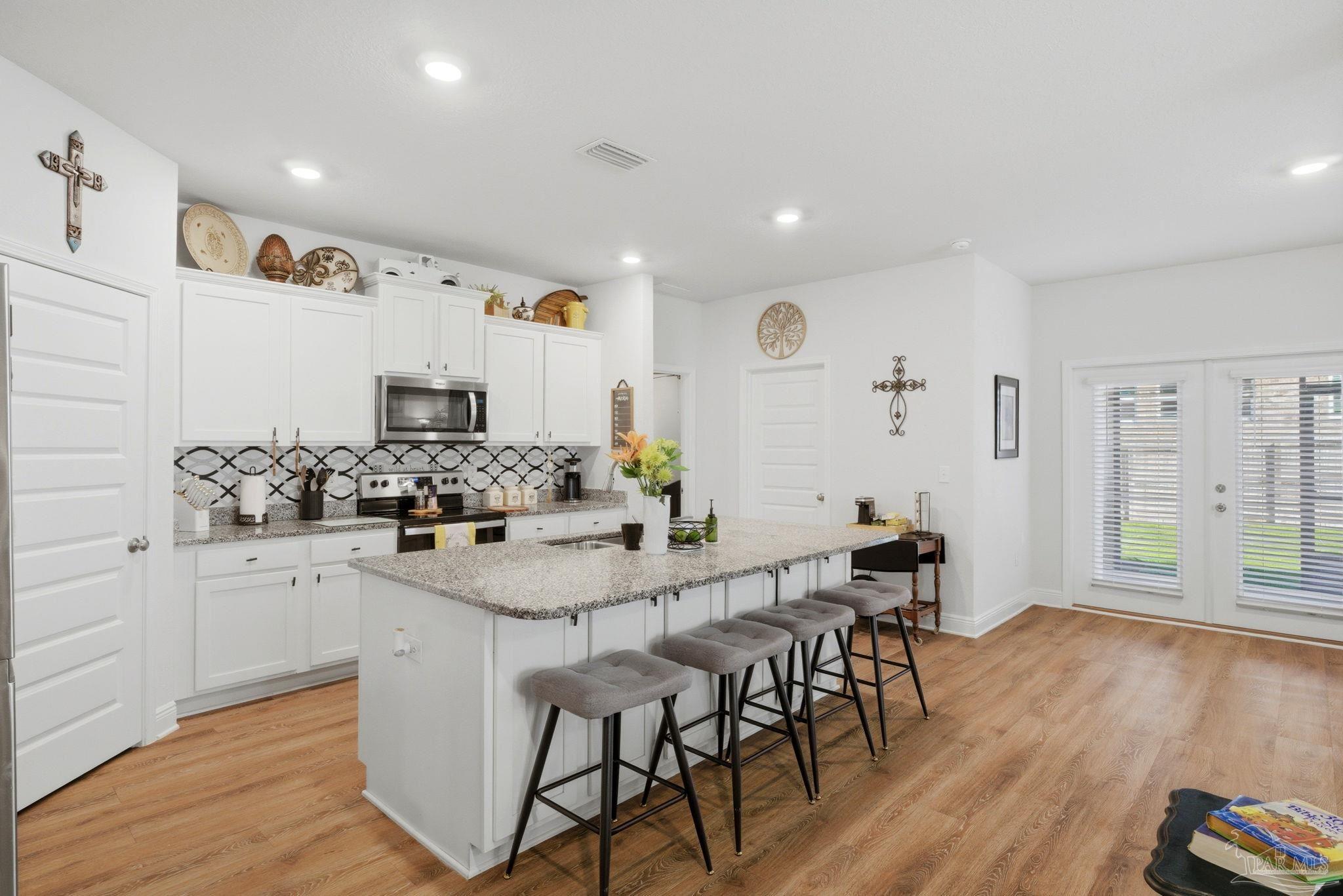 7829 Burnside Loop Pensacola, FL 32526 - Photo 14 of 34 a kitchen with stainless steel appliances kitchen island granite countertop a sink and cabinets