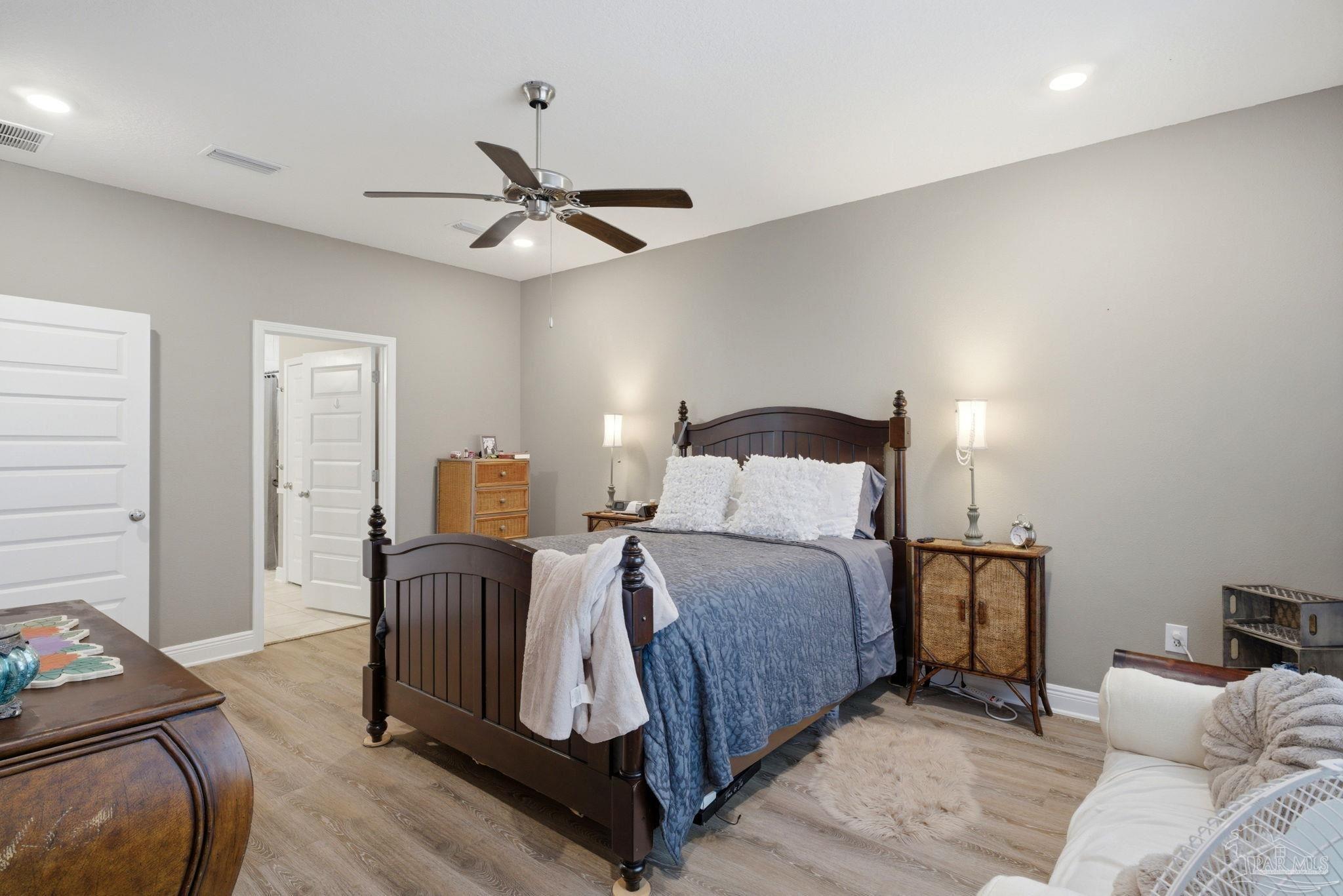 7829 Burnside Loop Pensacola, FL 32526 - Photo 19 of 34 a bedroom with a bed and wooden floor