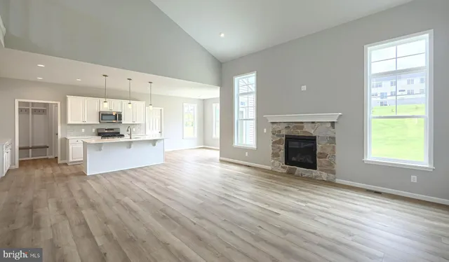 a view of kitchen with granite countertop stainless steel appliances wooden floor and a window