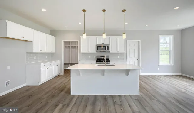 a kitchen with stainless steel appliances granite countertop wooden floors sink and cabinets