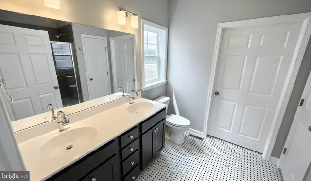 a bathroom with a sink a toilet a tub and shower