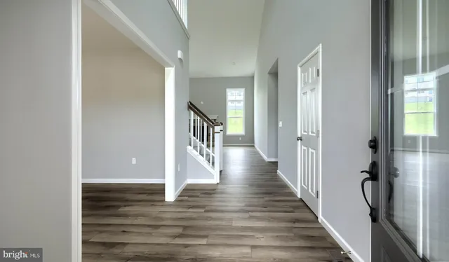 a view of a hallway with wooden floor and staircase