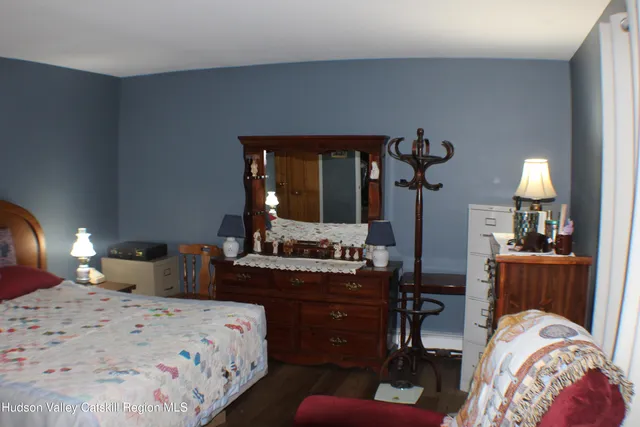 a bedroom with bed a mirror and lamp