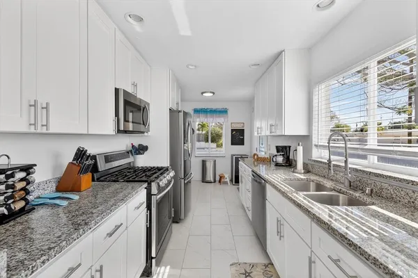 a kitchen with a sink stove top oven and cabinets