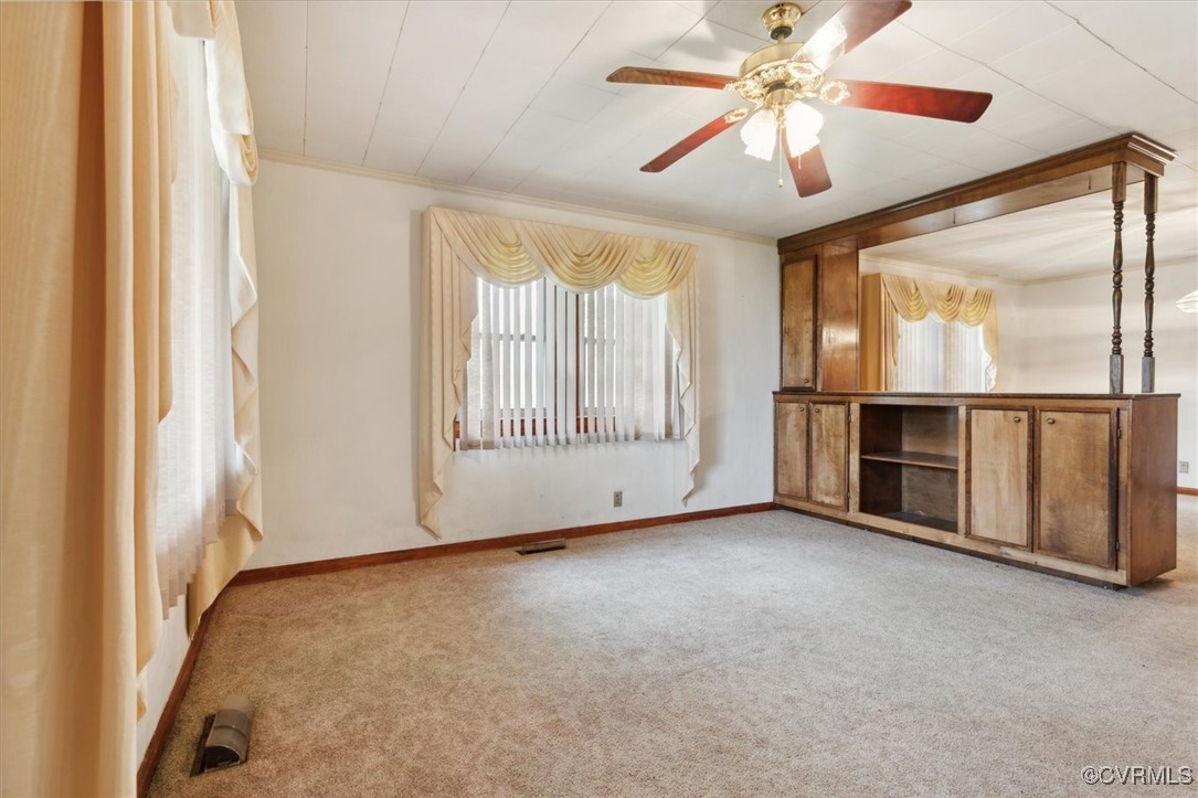 456 Queens Creek Road Williamsburg, VA 23185 - Photo 5 of 44 an empty room with chandelier fan and windows