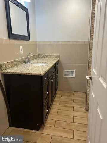 a bathroom with a granite countertop sink and a mirror