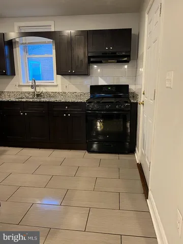 a kitchen with a sink and a stove top oven