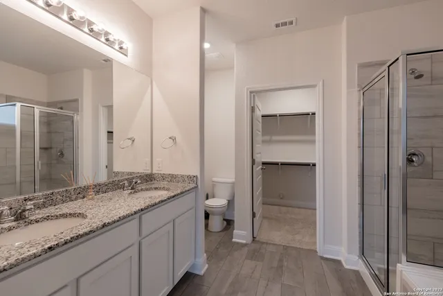 a bathroom with a granite countertop sink toilet and shower